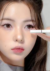 Close-up of a person applying makeup with a brush near their eye.