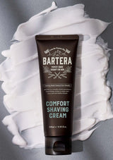 Bartera Comfort Shaving Cream tube with white shaving cream on a gray background