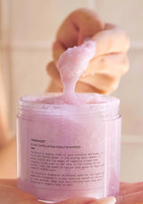 Pink shampoo bar in a jar with a blurred background