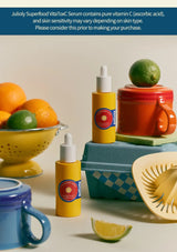 Two yellow bottles with droppers on a table with fruits and kitchen items.