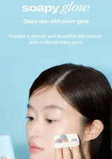 Person applying a product to their face with a blue background and 'soapy glow' text.