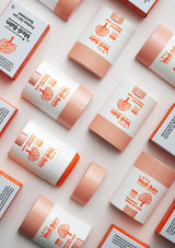 Medi-Balm products arranged on a light pink background