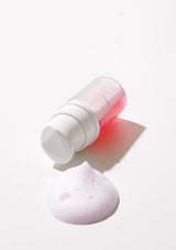 Skincare product with a pump and pink sponge on a white background