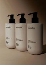 Three white bottles with black pumps labeled 'hersteller' on a beige background