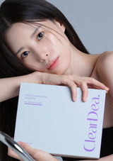 Woman holding a 'Clear Dea' product box against a gray background