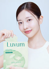 Woman holding a Luvum green citrus vitamin C gel mask against a light blue background