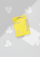 Yellow package with white clover-shaped items on a light gray background