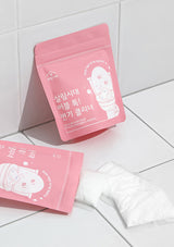 Two pink packaging bags with a cartoon character on a white tiled floor.
