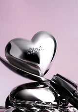 Heart-shaped compact mirror with Olay logo on a pink background