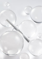 Skincare serum bottle with dropper surrounded by bubbles on a light gray background
