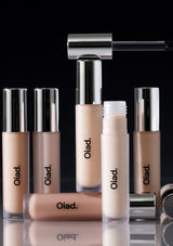 Collection of Oiad makeup products including lipsticks and a concealer on a black background