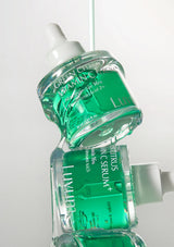 Two green skincare bottles stacked on a white background