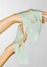Person wearing light green silicone gloves on a plain background