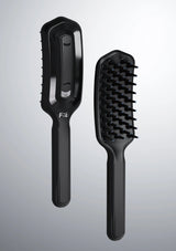 Black hairbrush with bristle head and handle on a gray background