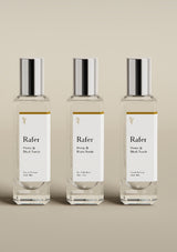Three Rafer perfume bottles with silver caps on a beige background