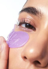 Person applying a purple eye patch to their eye