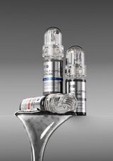 Three medical ampoules on a metallic surface with a gray background