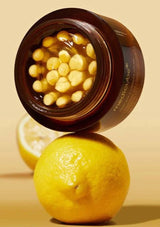 Jar of cosmetic product with lemons on a beige background
