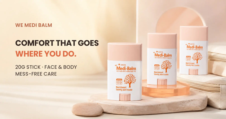 Three WE MEDI BALM moisture sticks staged on peach and stone travel-inspired plinths