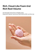 Hand holding a pink cloud-like foam with text about hair care on a beige background