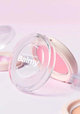 Pink makeup compact with 'Balmy' branding on a light pink background