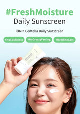 Person holding iUNIK Centella Daily Sunscreen with product on face against a blue background