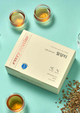 Box of Melon Tea with two glasses of tea and scattered tea leaves on a light blue background