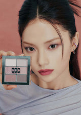 Woman holding a makeup palette with a blurred background