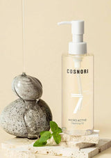 Cosnori micro active cleansing oil bottle with a pump on a neutral background