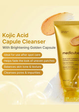 Medicube Kojic Acid Capule Cleanser tube in metallic gold packaging, shown alongside a scoop of beige capule powder and text highlighting skin benefits on a pale yellow background.
