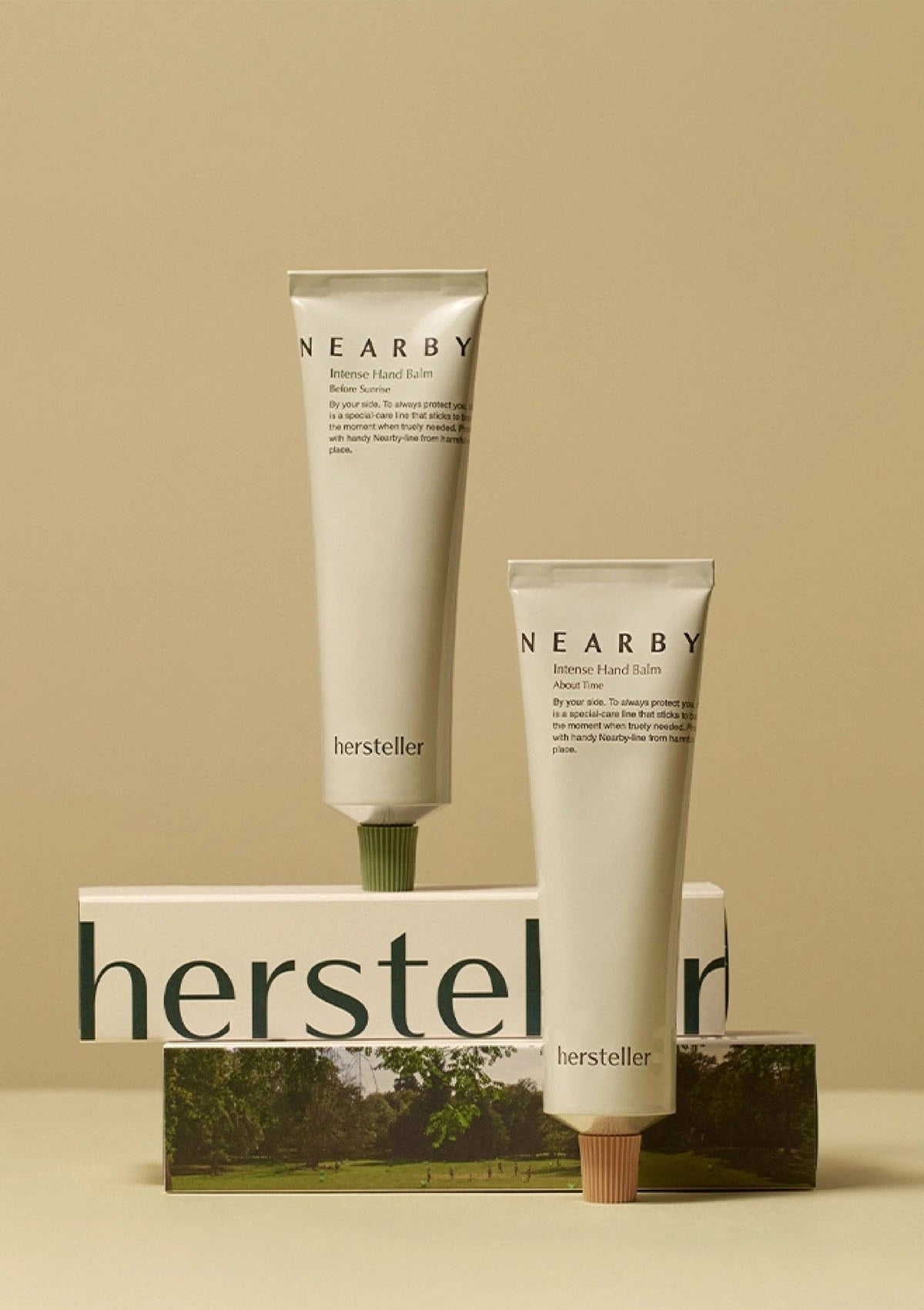 Two tubes of 'Nearby' hand balm by 'hersteller' on a beige background