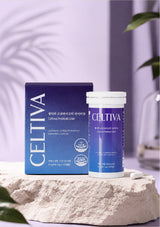 Celtiva Cellular Pro-Defense Kit, featuring a blue and white product box and a matching cylindrical bottle, displayed on a textured stone slab with a soft purple background.