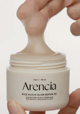 Arencia Rice Mucin Glow Serum 30 jar held by a hand on a light background
