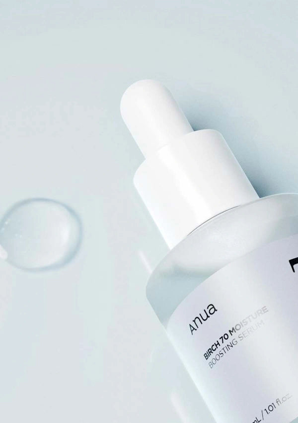 Skincare dropper bottle with 'ANUA' branding on a light gray background
