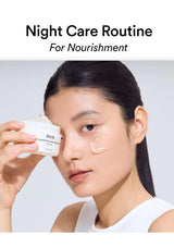 A woman holding a white cosmetic jar near her face while wearing a cream product on her cheek, with the text 'Night Care Routine For Nourishment' at the top.