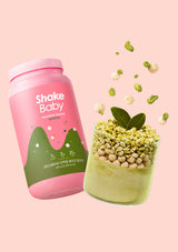 Pink 'Shake Baby' protein shake container with green contents on a pink background