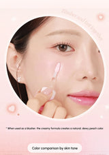 Person applying cream blush to their cheek with a pink background