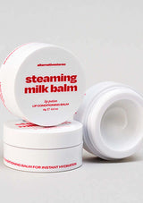 White containers of steaming milk balm with red text on a light gray background