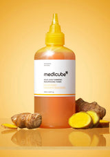 Mediclebe bottle with turmeric root and pieces on a yellow background