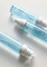 Two bottles of Aqua skincare product on a light background