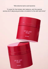 Red jars of 'Lift Up Light Cream' with text on a pink background