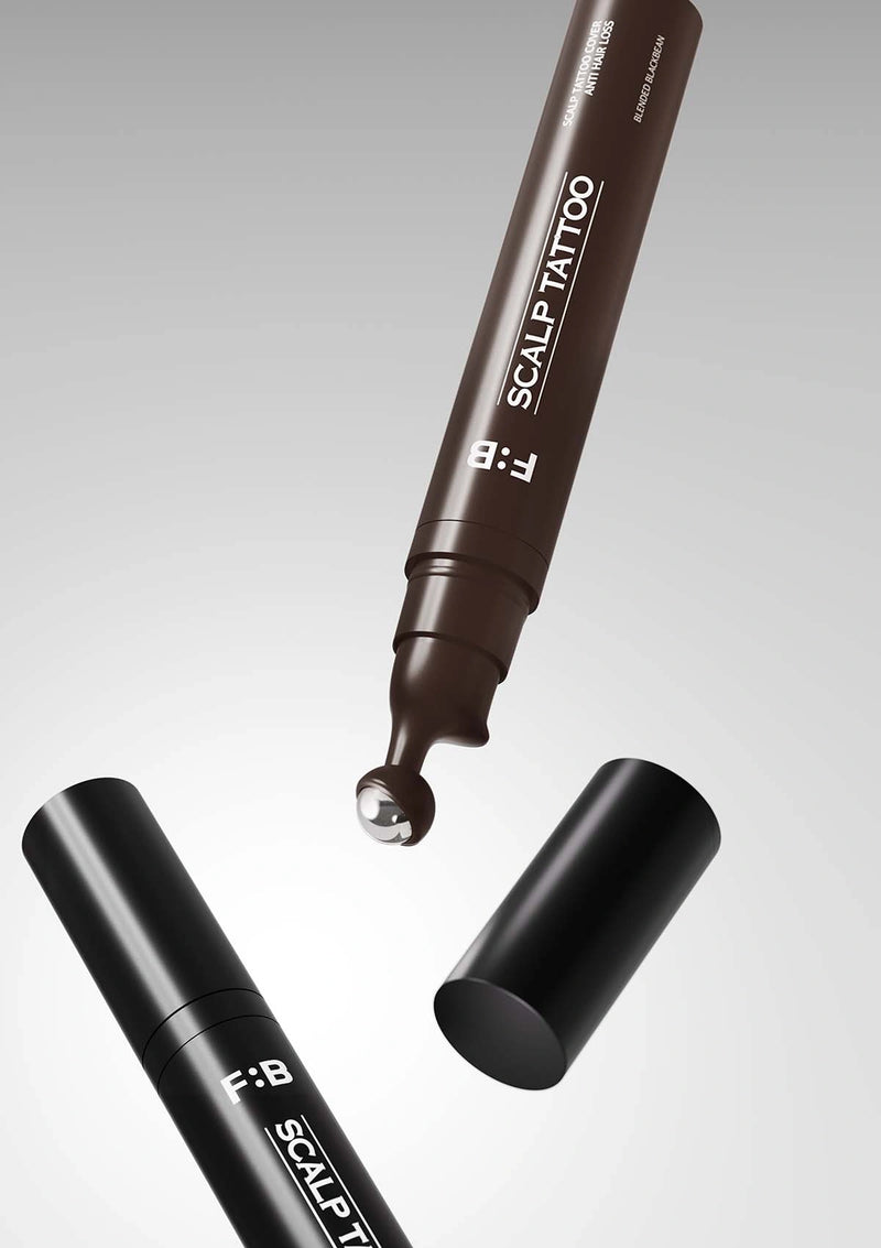 Two scalp tattoo pens with a droplet of ink on a gray background