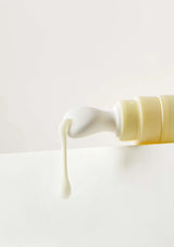 Cream being squeezed from a tube onto a white surface