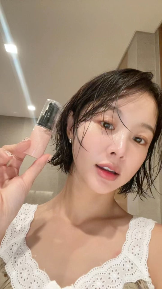 Woman holding a VELY VELY skincare product during a dewy-skin routine