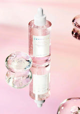 Skincare bottle with dropper on a pink background