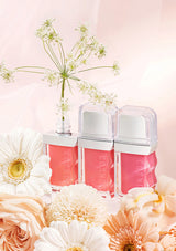 Three pink bottles with white caps on a pink background with flowers