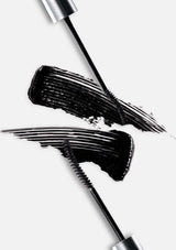 Mascara wand with black ink smears on a white background