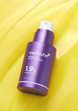 Purple Medicube serum bottle on a yellow background