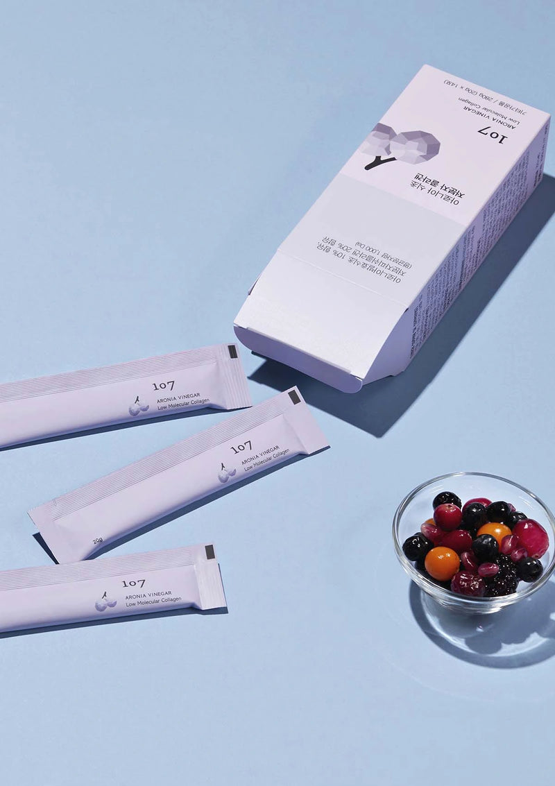 Zoi white cream packets with a box and a bowl of berries on a light blue background