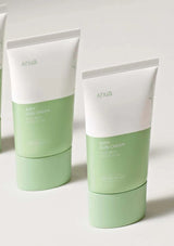 Two green and white tubes of Anua airy sun cream on a light background